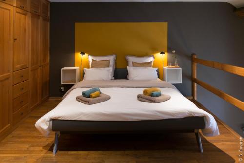 een slaapkamer met een groot bed met 2 kussens erop bij Les Petits Secrets de Nonna-Chambre d hote dinant in Flavion