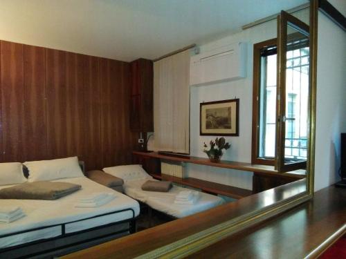 a room with two beds and a mirror at Sestiere Dorsoduro Venezia, a due passi dal ponte dei Pugni in Venice