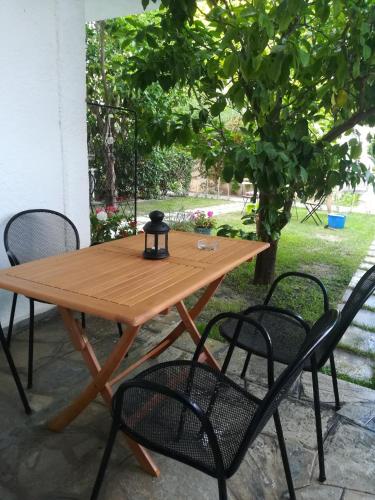 a wooden table and chairs on a patio at Christina Apartments in Fourka