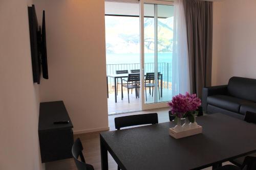 a living room with a dining room table with a view of the ocean at My Lake Apartments in Malcesine