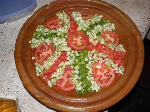 a plate of tomatoes and onions on a table at Maison Boutchrafine in Erfoud
