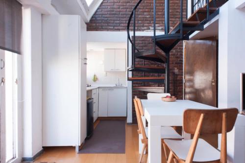 cocina y comedor con mesa blanca y sillas en Dúplex en Ático en Microcentro en Buenos Aires