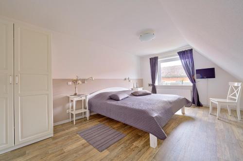 biała sypialnia z łóżkiem i oknem w obiekcie Ferienwohnung Zollstraße 2. Etage w mieście Bleckede