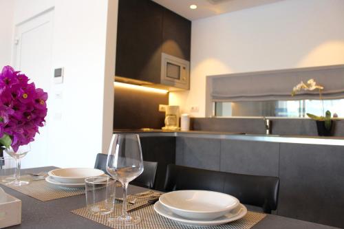 a dining room table with plates and wine glasses at My Lake Apartments in Malcesine