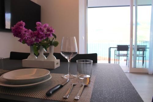 a table with a plate and a glass of wine at My Lake Apartments in Malcesine
