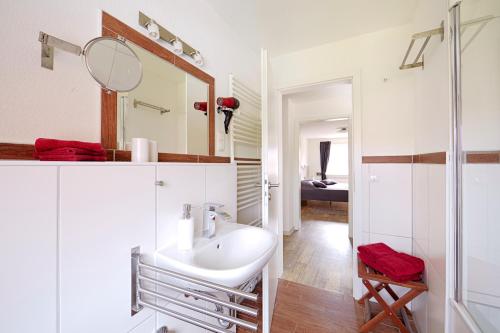 a white bathroom with a sink and a mirror at Ferienwohnung Zollstraße 2. Etage in Bleckede