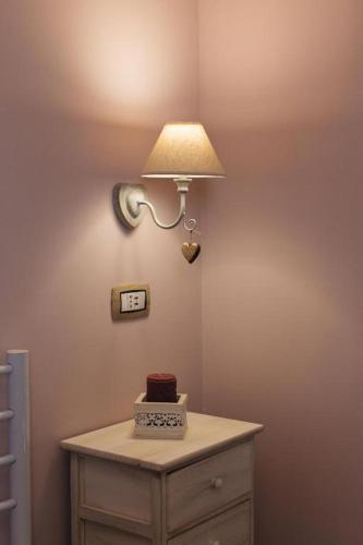 a table with a cake and a light on a wall at Alle Scalette B&B in Lauria