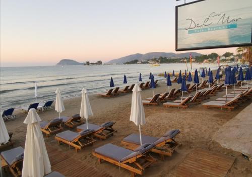 a group of lounge chairs and umbrellas on a beach at Casa Del Mar in Laganas