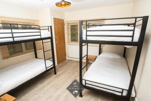 two bunk beds in a room with a sign on the floor at Celtic House in Merthyr Tydfil
