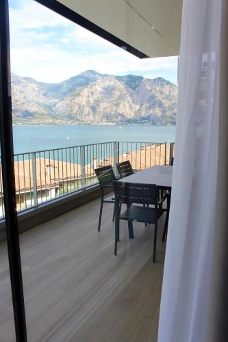 a balcony with a table and chairs and a view of the ocean at My Lake Apartments in Malcesine