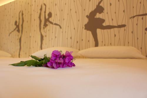 a bouquet of purple flowers sitting on top of a bed at My Lake Apartments in Malcesine