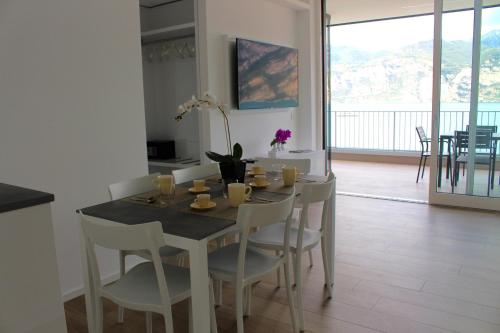 a dining room table with white chairs and a table at My Lake Apartments in Malcesine