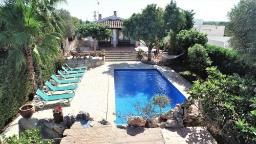 a swimming pool with lounge chairs and a house at Villa para 6 con piscina privada. in Ciutadella
