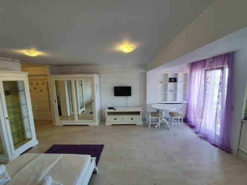 a living room with a table and a tv at Airport Residence in Otopeni