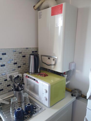 a kitchen with a microwave on top of a counter at Airport Residence in Otopeni