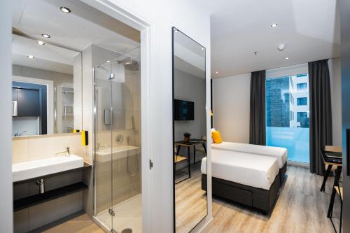 a bathroom with a bed and a sink and a mirror at Staycity Aparthotels Venice Mestre in Mestre