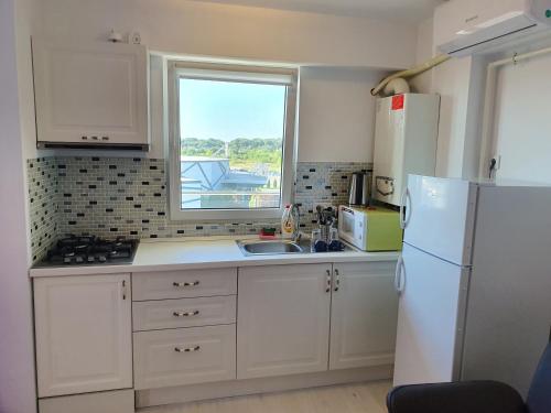 a kitchen with a white refrigerator and a window at Airport Residence in Otopeni