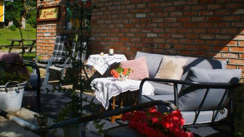 a patio with two chairs and a table with flowers at Fjøset på Knardal in Neset