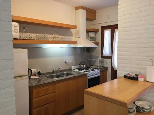 a kitchen with a sink and a stove at Valeria House Rental Suites in Valeria del Mar