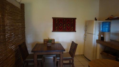 a kitchen with a wooden table and a refrigerator at Casa Aditi in Mazunte