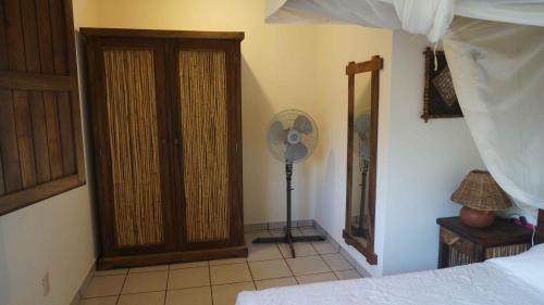 a bedroom with a fan next to a door at Casa Aditi in Mazunte