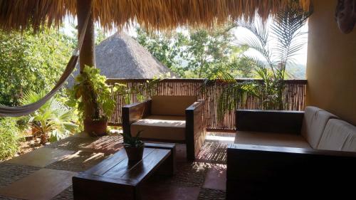 a patio with a couch and a chair and a table at Casa Aditi in Mazunte