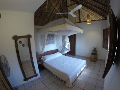 una camera con letto a baldacchino e specchio di Casa Aditi a Mazunte