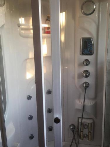a shower in a bathroom with a phone in it at Riverside Villa Matka in Skopje