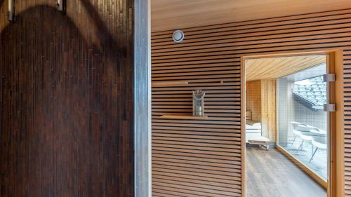 a pivot door in a house with a wooden wall at Aparthotel Alpinresort Damüls in Damuls