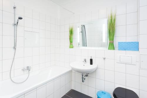 Un baño blanco con lavabo y bañera. en Labyrinth, en Berlín