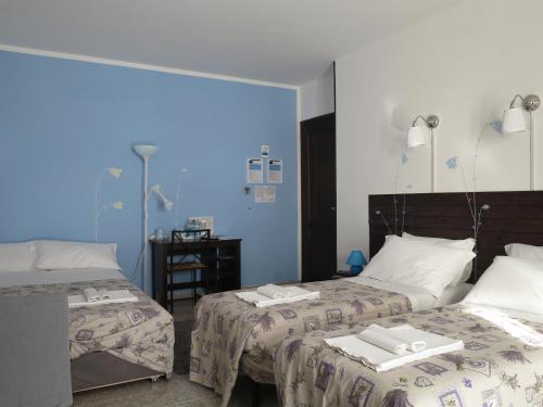 sypialnia z 2 łóżkami i niebieską ścianą w obiekcie BiancoCancello w mieście Sacrofano