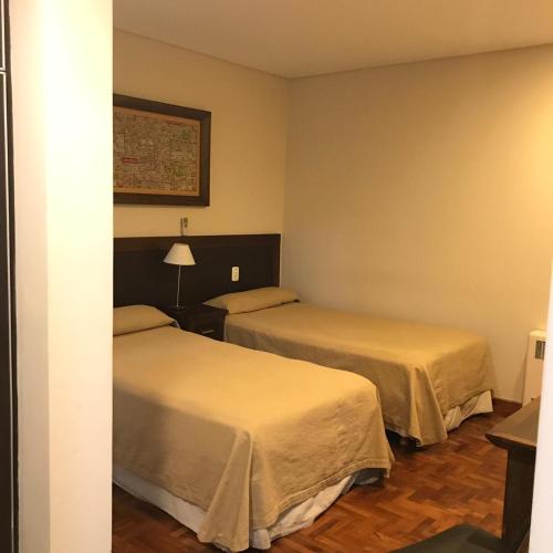 a hotel room with two beds in a room at Hotel Cervantes in Mendoza
