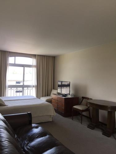 a bedroom with a bed and a table and a couch at Hotel Cervantes in Mendoza