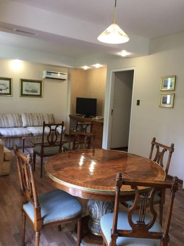 a living room with a wooden table and chairs at Hotel Cervantes in Mendoza