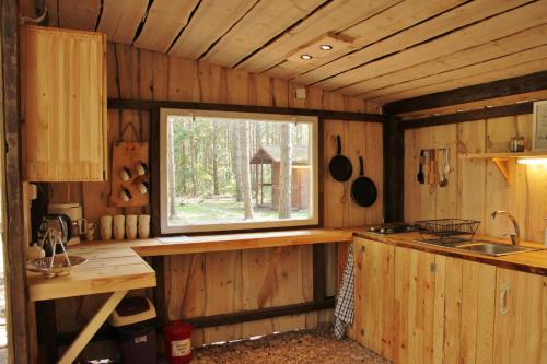 a kitchen with a window in a log cabin at Kuuli Puhkemajad in Tagaranna