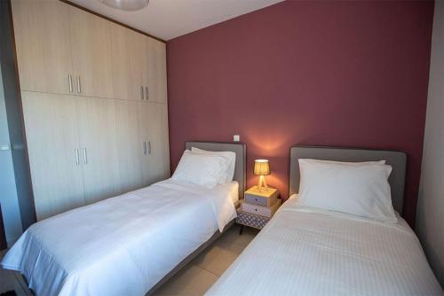 dos camas sentadas una al lado de la otra en un dormitorio en V Luxury Apartment 2, en Ioannina