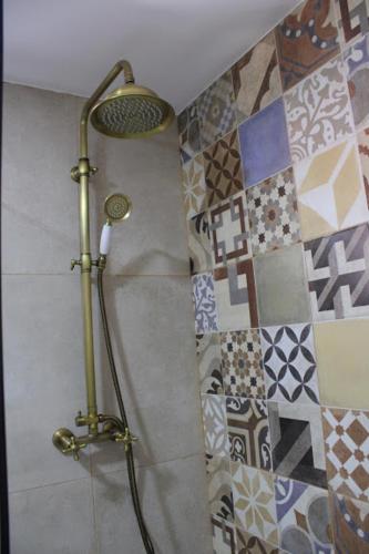 a shower in a bathroom with tiles on the wall at A Casinha da Padaria, Soajo in Soajo