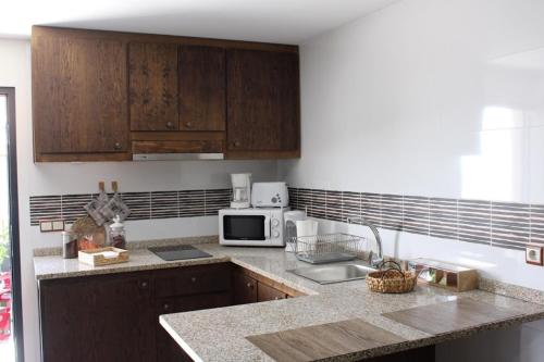 cocina con armarios de madera y encimera en A Casinha da Padaria, Soajo, en Soajo