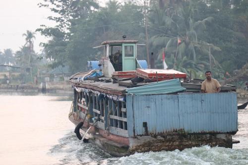 a man is standing on a boat in the water at Beach Paradise Day Cruise Houseboat in Alleppey