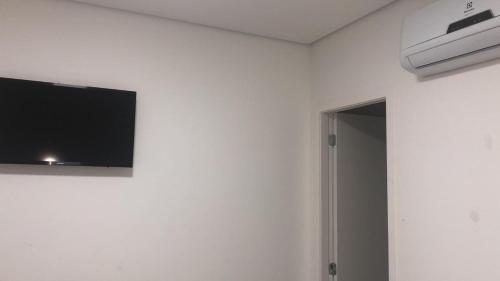 a room with a flat screen tv on a wall at Hotel Novo Oriente Brás in Sao Paulo