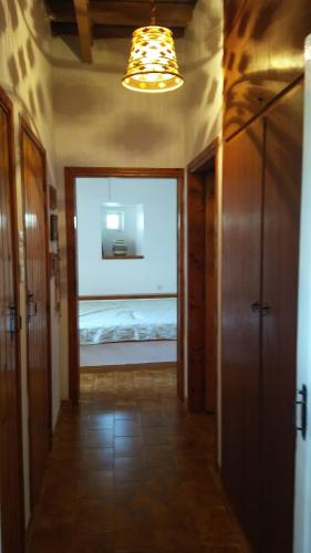 a hallway with a bedroom with a bed and a light at The large bougainvillea house in Kýthira
