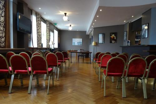 a waiting room with red chairs and a table at Le Grand Hotel in Tours