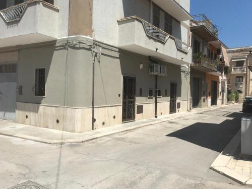 an empty street with a building with doors on it at La Maison Doppia in Stornara