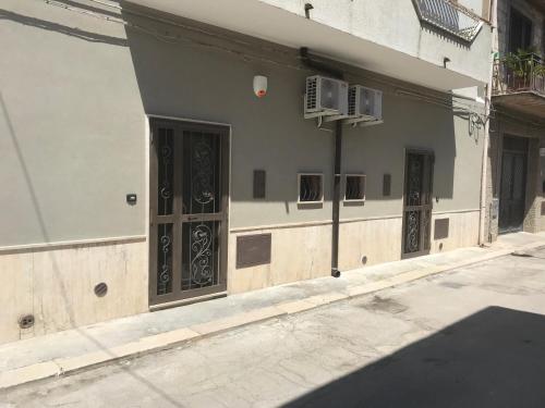 a building with doors on the side of a street at La Maison Doppia in Stornara