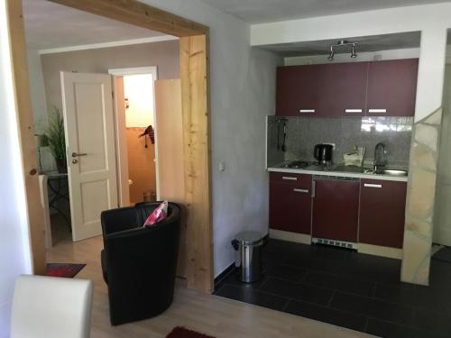 a kitchen with brown cabinets and a black chair at Endbach-life in Bad Endbach