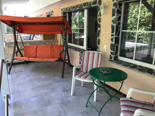 a porch with a swing and a table and chairs at Endbach-life in Bad Endbach