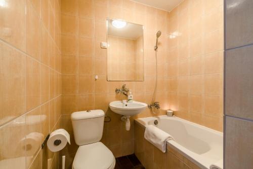 W łazience znajduje się toaleta, umywalka i wanna. w obiekcie Dom Wypoczynkowy Caro w mieście Krynica Morska