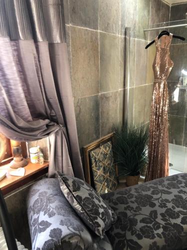 a bedroom with a bed and a dress on a wall at Belmont House Boutique - the Kingsley collection in Berwick-Upon-Tweed