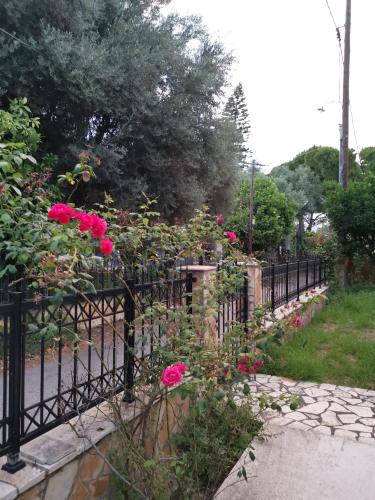 a black fence with pink roses on it at Angel's Place by the Sea in Diakopto