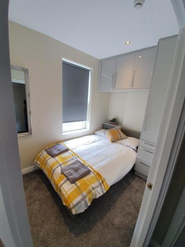 a bedroom with a bed and two windows at Harvey Apartments in Derry Londonderry